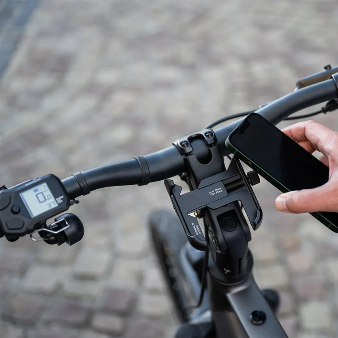 A close-up of the handlebars with phone holder and display on the Cortina E Mozzo electric bike