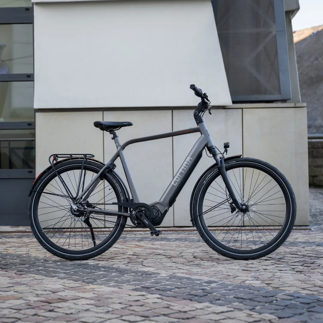 Elegant Electric Bicycle Cortina E Mozzo parked in front of a modern building