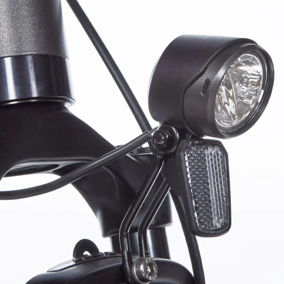 Close-up of the front headlight and reflector of the Cortina E Mozzo electric bike