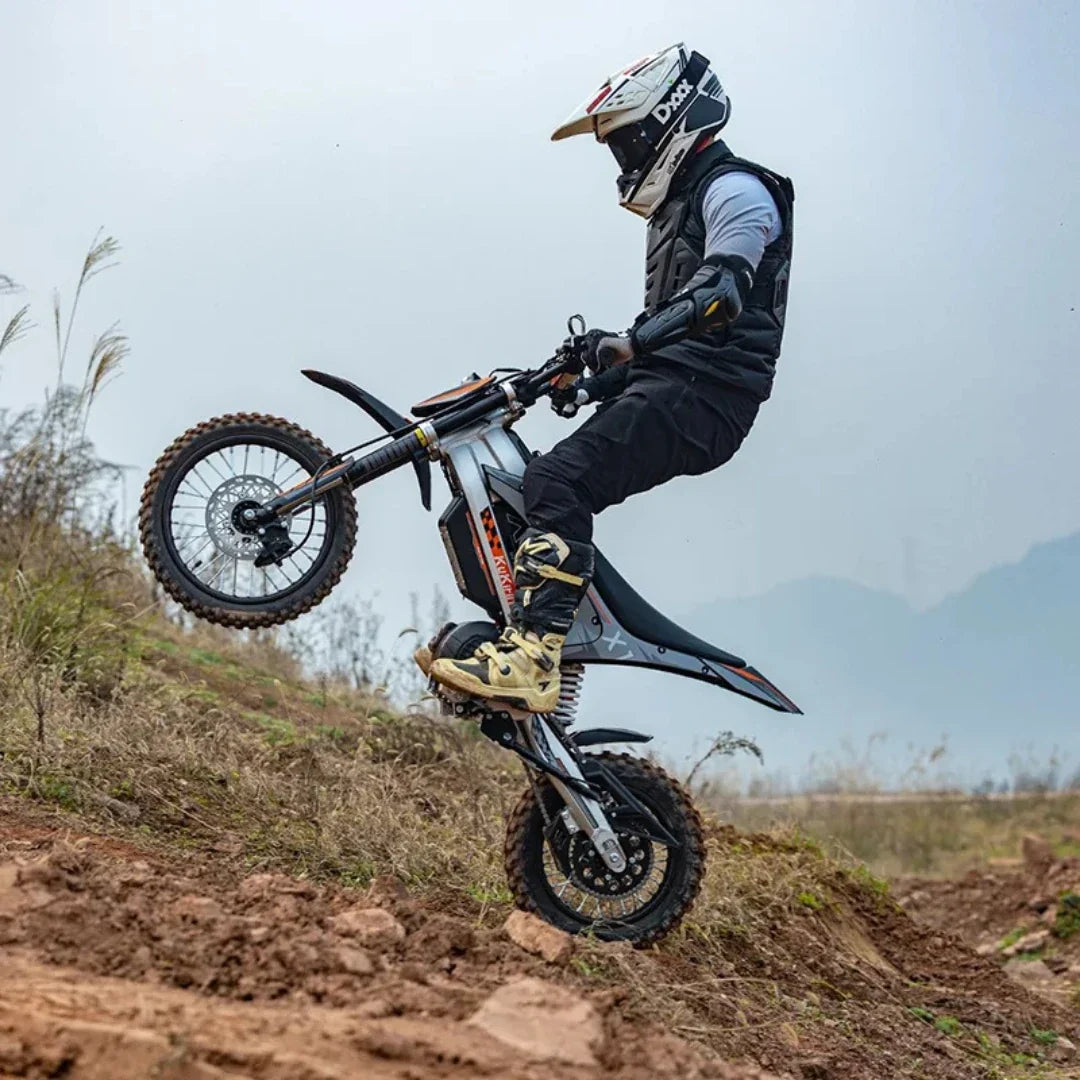 KuKirin X1 – Fahrer, der ein Wheelie auf einem Feldweg macht