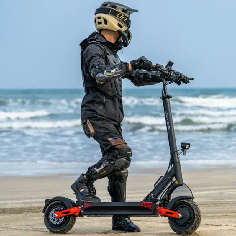 Electric scooter Joyor T10 – rider on beach, side view