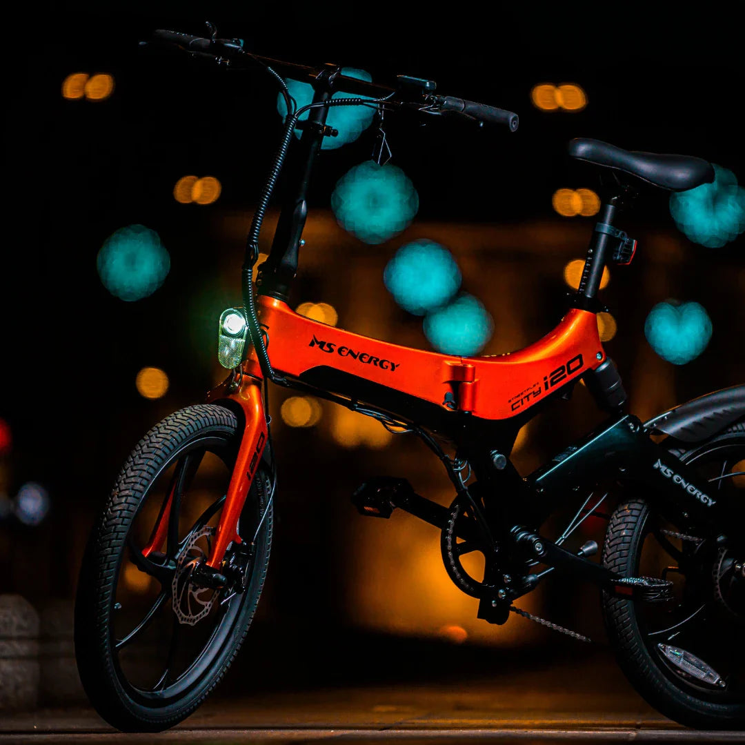 Electric Bike Ms Energy I20 features a vibrant orange frame, sleek design, and integrated front light for visibility.