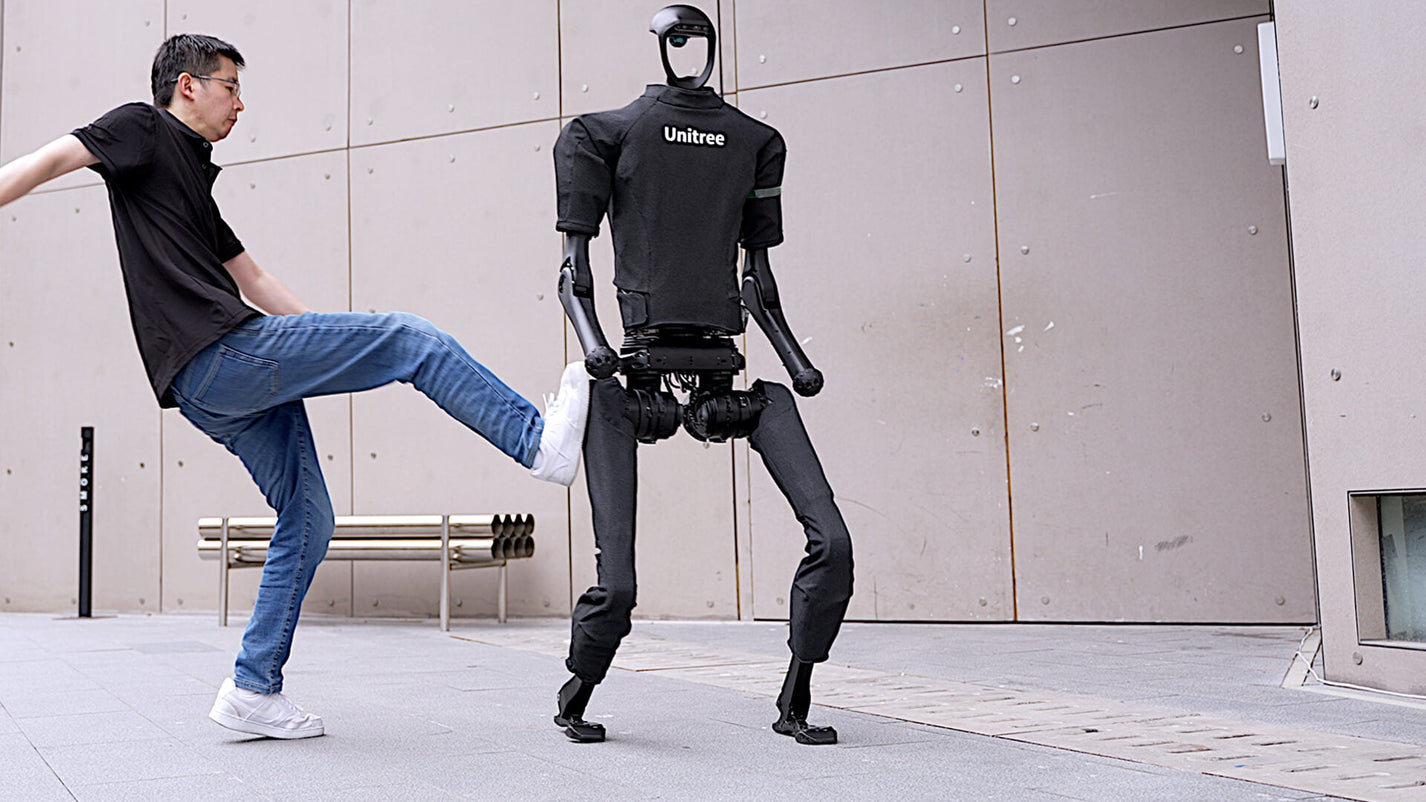 Unitree H1 – man kicking robot outdoors