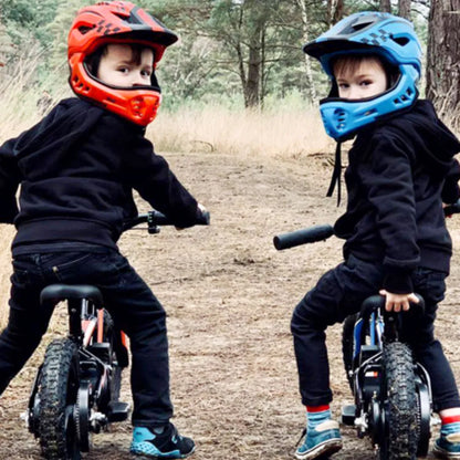 Electric Bike Apollo Sedna 16 Rxf features two children riding in helmets, showcasing outdoor adventure fun.