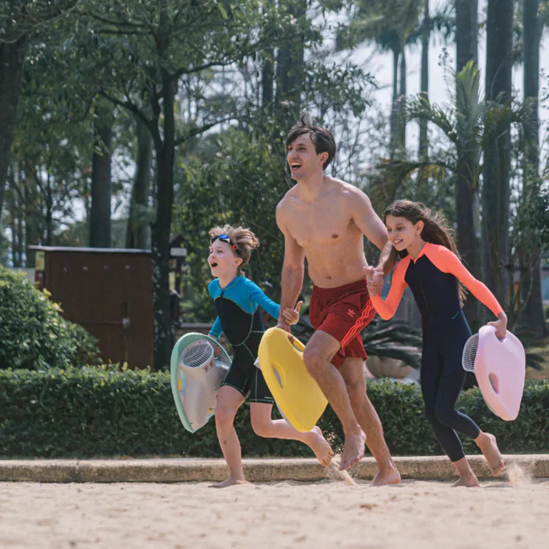 Electric Swim Board Asiwo Mako, three kids and an adult running on the beach with swim boards.