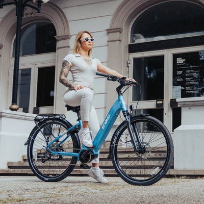 Electric Bike Econo Mare City Eecalk Auto, stylish blue electric bike, woman riding, modern urban setting.