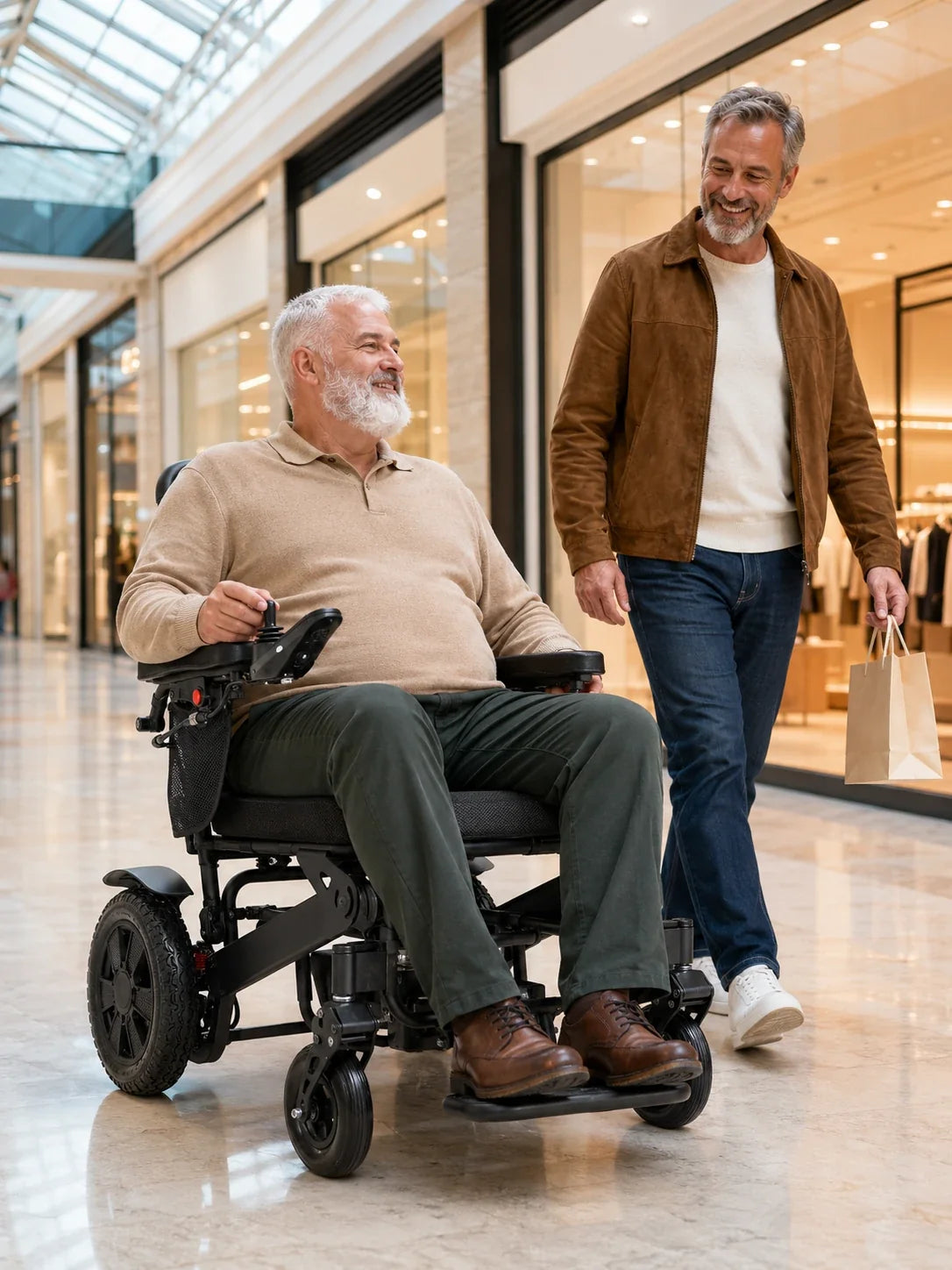 Electric wheelchair ComfyGO Majestic 440 HD Plus – seated man smiling beside a companion in a shopping mall