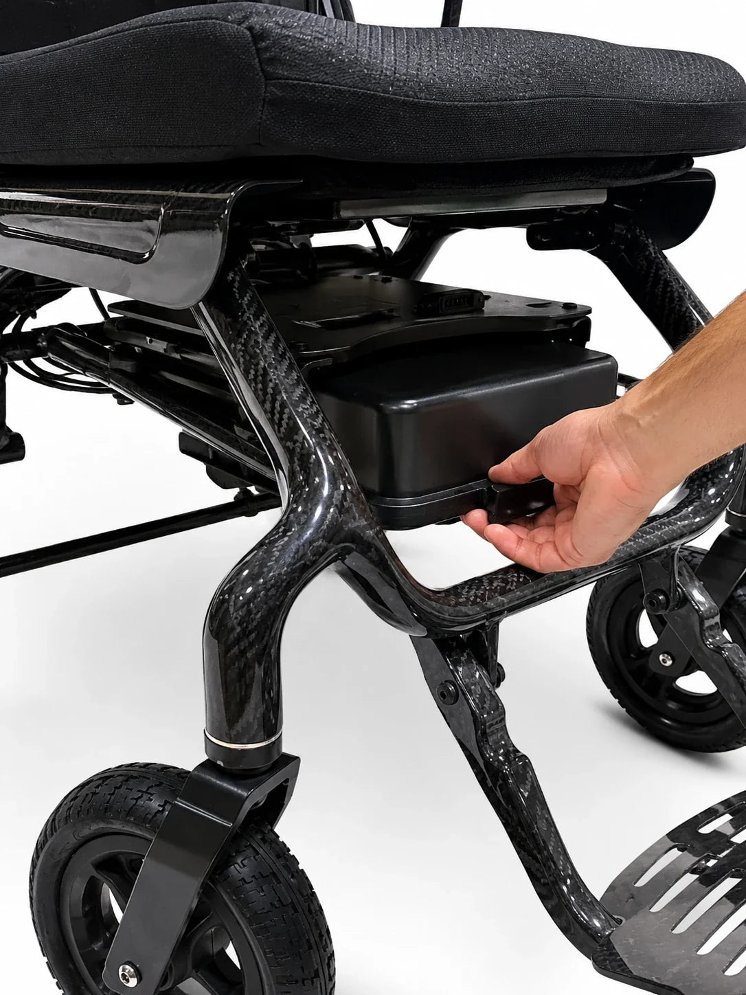 Electric wheelchair ComfyGO IQ-Carbon – close-up of a hand removing the battery pack from the frame