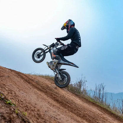 KuKirin X1 – rijder die een wheelie uitvoert op een zandheuvel