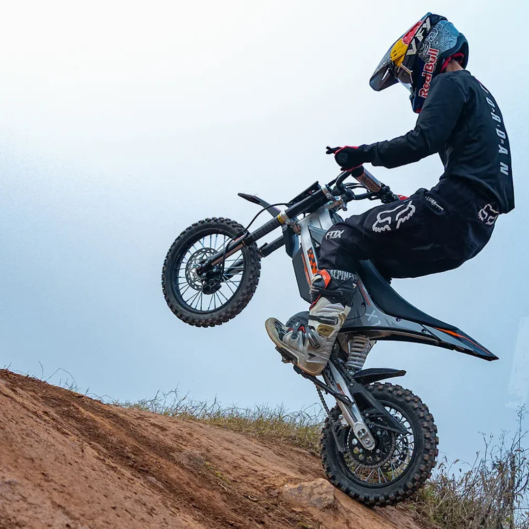 KuKirin X1 – rijder die een wheelie uitvoert op een zandheuvel