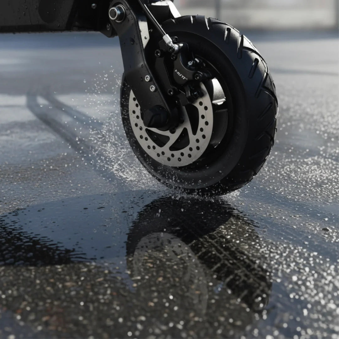 Electric scooter Dualtron Forever – front wheel splashing through puddle