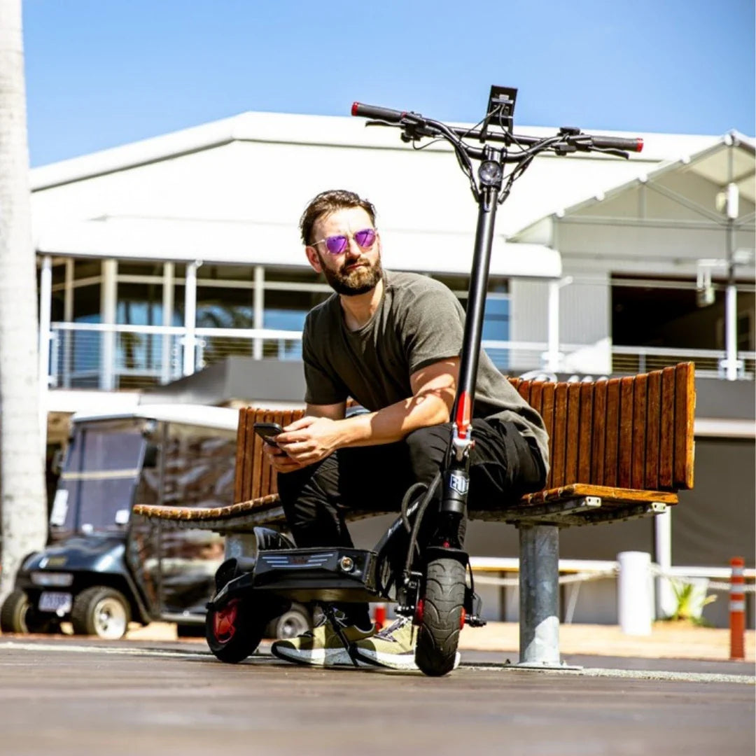 Electric scooter Kaabo Mantis King GT – person sitting on bench with scooter