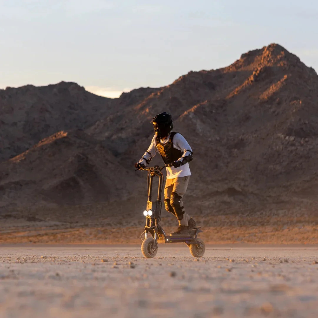 Electric scooter Kaabo Wolf King GTR MAX – rider on desert trail at sunset