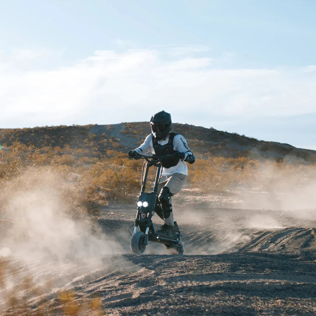 Electric scooter Kaabo Wolf King GTR MAX – rider on dirt track, dust clouds