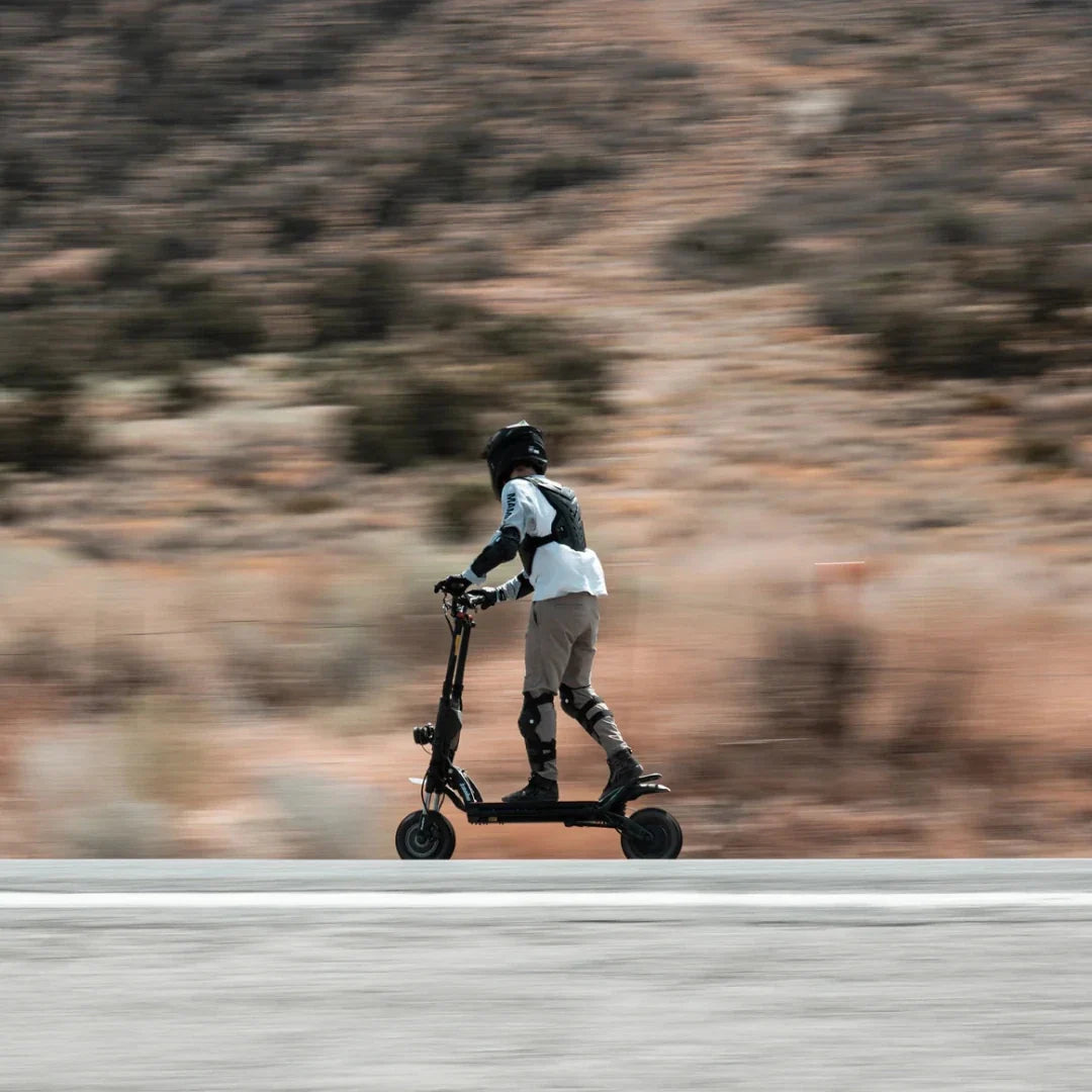 Electric scooter Kaabo Wolf King GTR MAX – rider on road, motion blur background