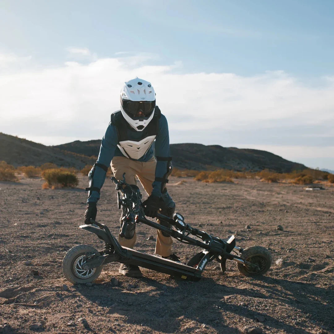Electric scooter Kaabo Wolf Warrior 11 MAX – person folding scooter in desert landscape