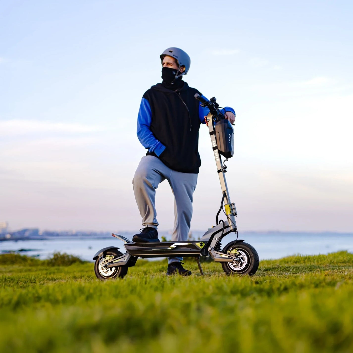 Electric scooter Langfeite C1 2026 – rider standing on grass by water