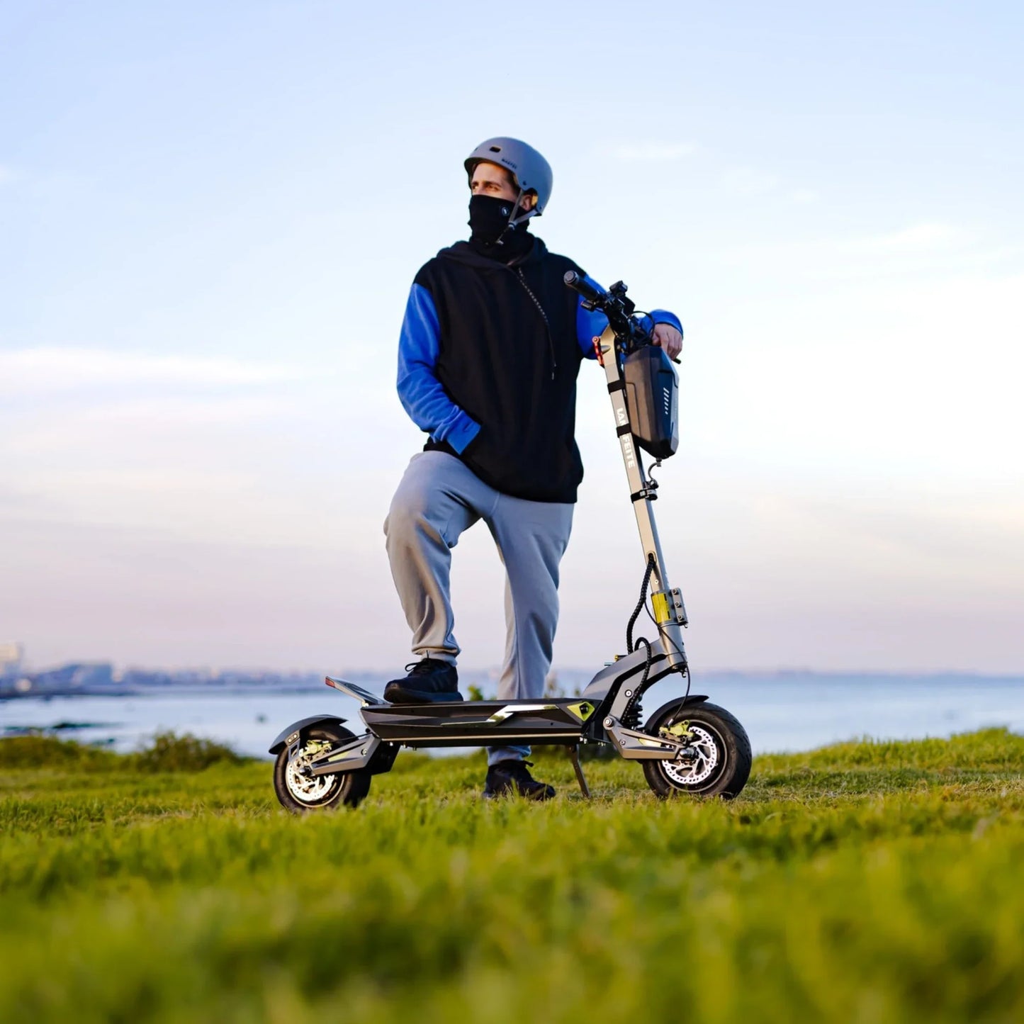 Electric scooter Langfeite C1 2026 – rider standing on grass by water