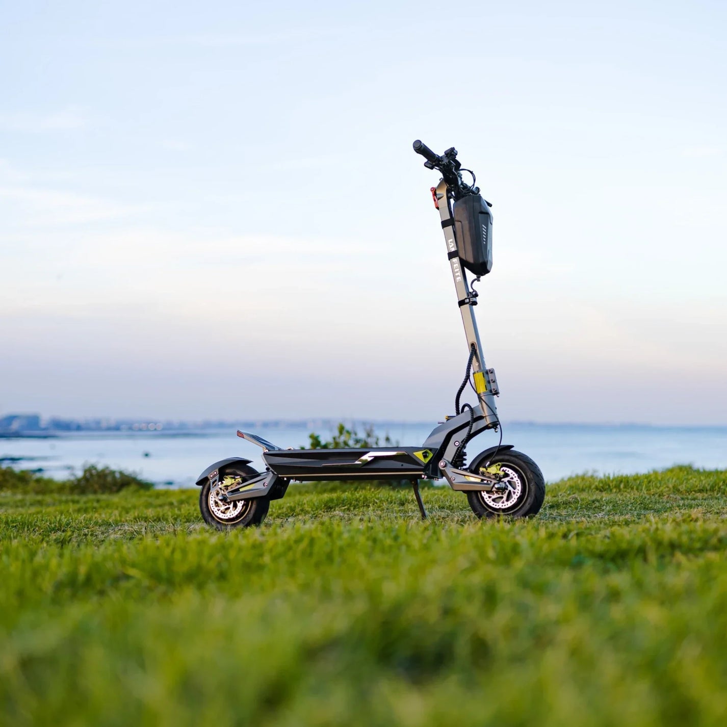 Electric scooter Langfeite C1 2026 – side view on grassy hill by sea