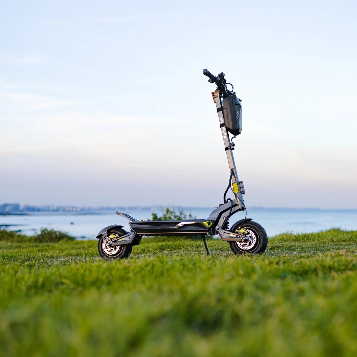 Electric scooter Langfeite C1 2026 – side view on grassy hill by sea