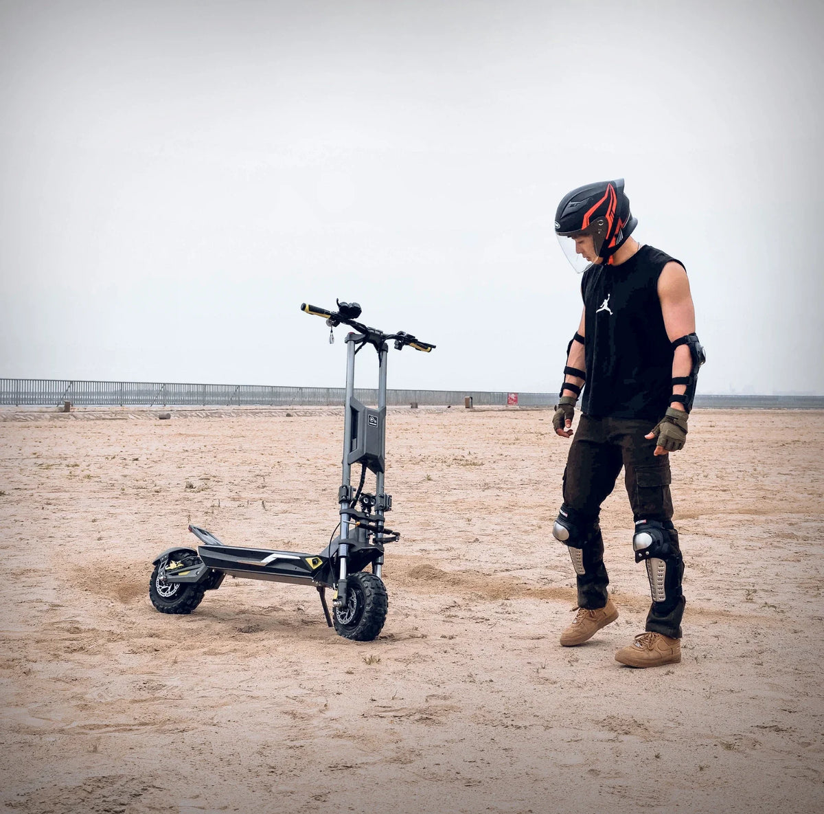 Electric scooter Langfeite H1 2026 – rider with protective gear on sand