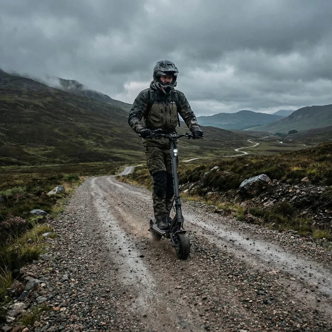 Electric scooter Teverun Fighter Mini PRO 2026 – rider on gravel road, mountains