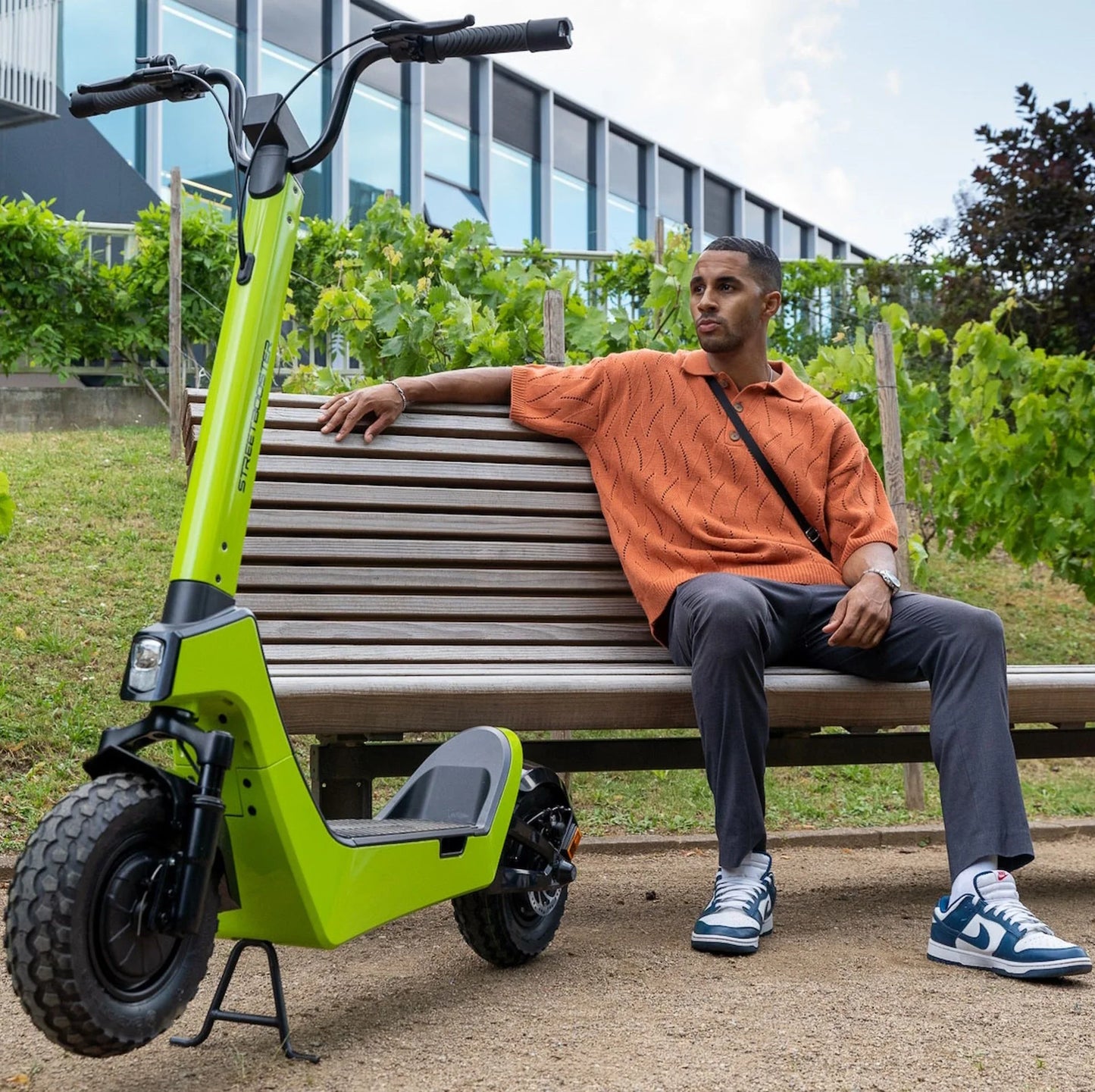 Electric scooter StreetBooster Castor – person sitting on bench next to scooter