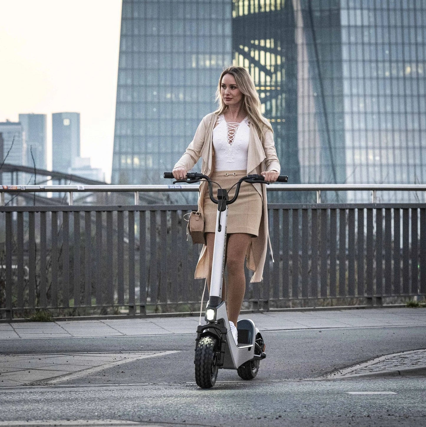 Electric scooter StreetBooster Castor – woman riding on street, white colour variant