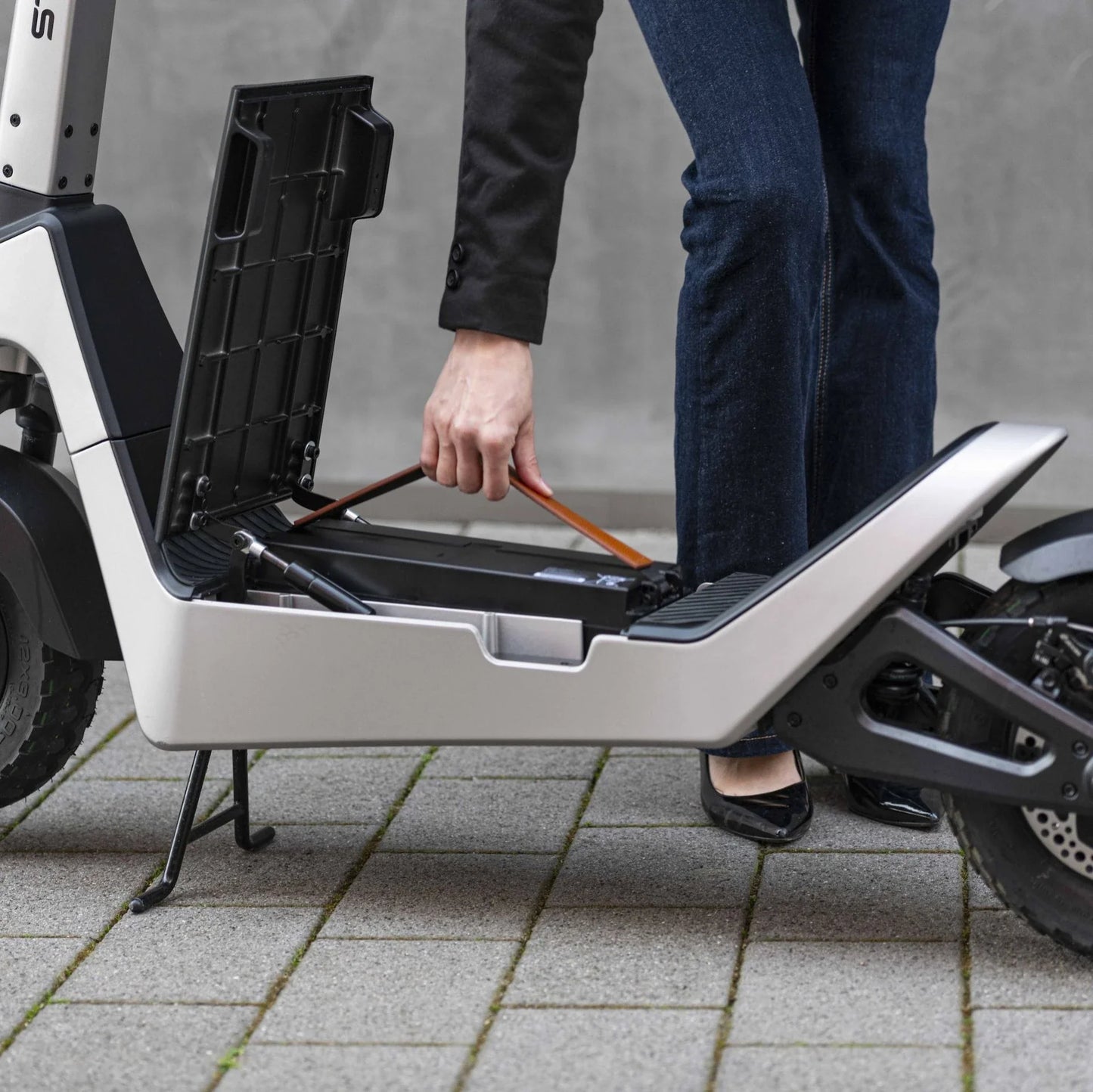 Electric scooter StreetBooster Castor – person removing battery from under seat