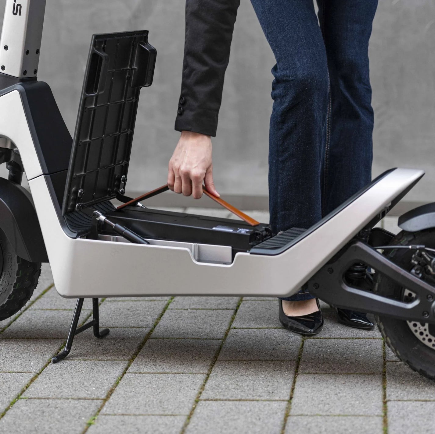Električni romobil StreetBooster Pollux – žena vadi bateriju ispod sjedala