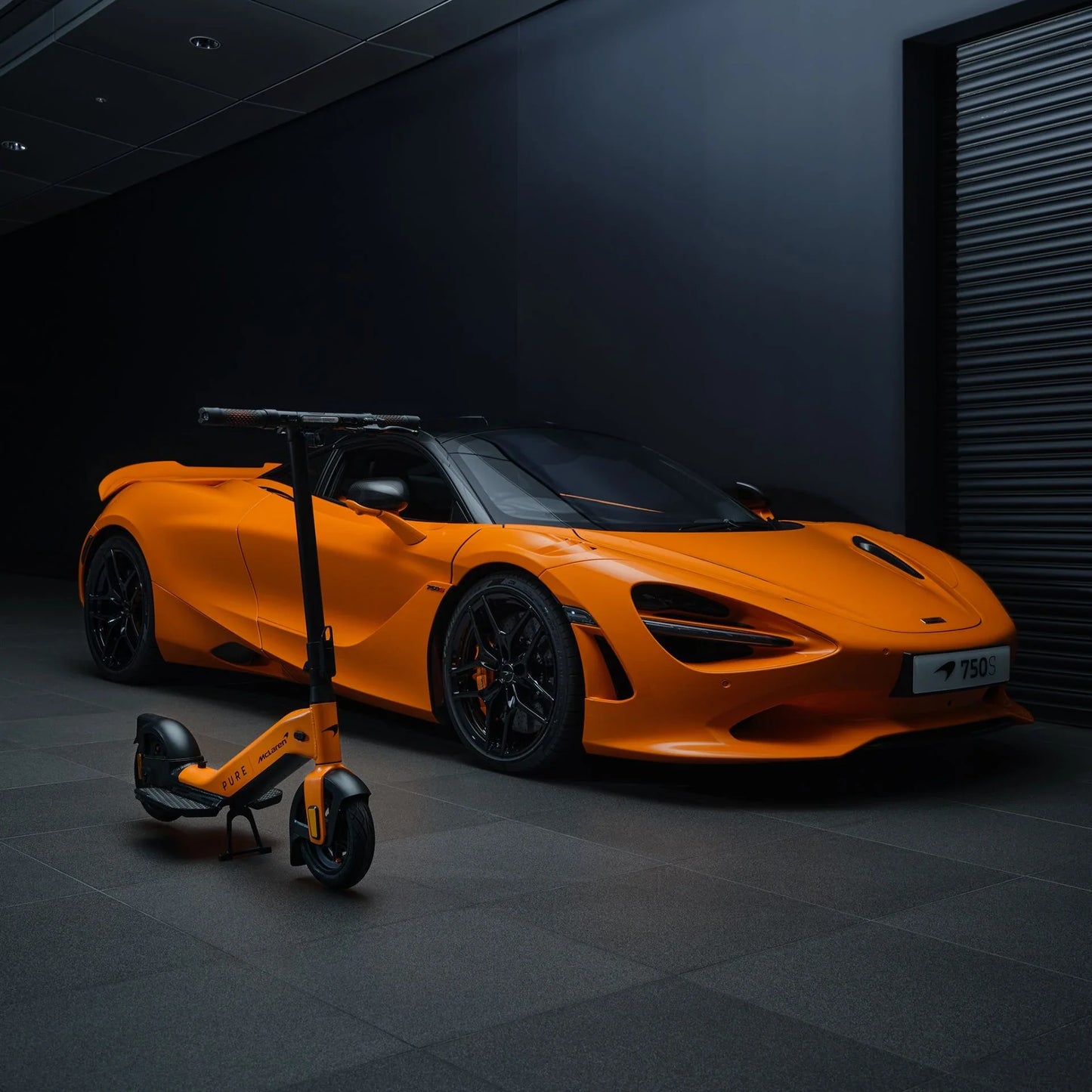 Electric scooter Pure Advance+ McLaren Edition – orange variant next to sports car