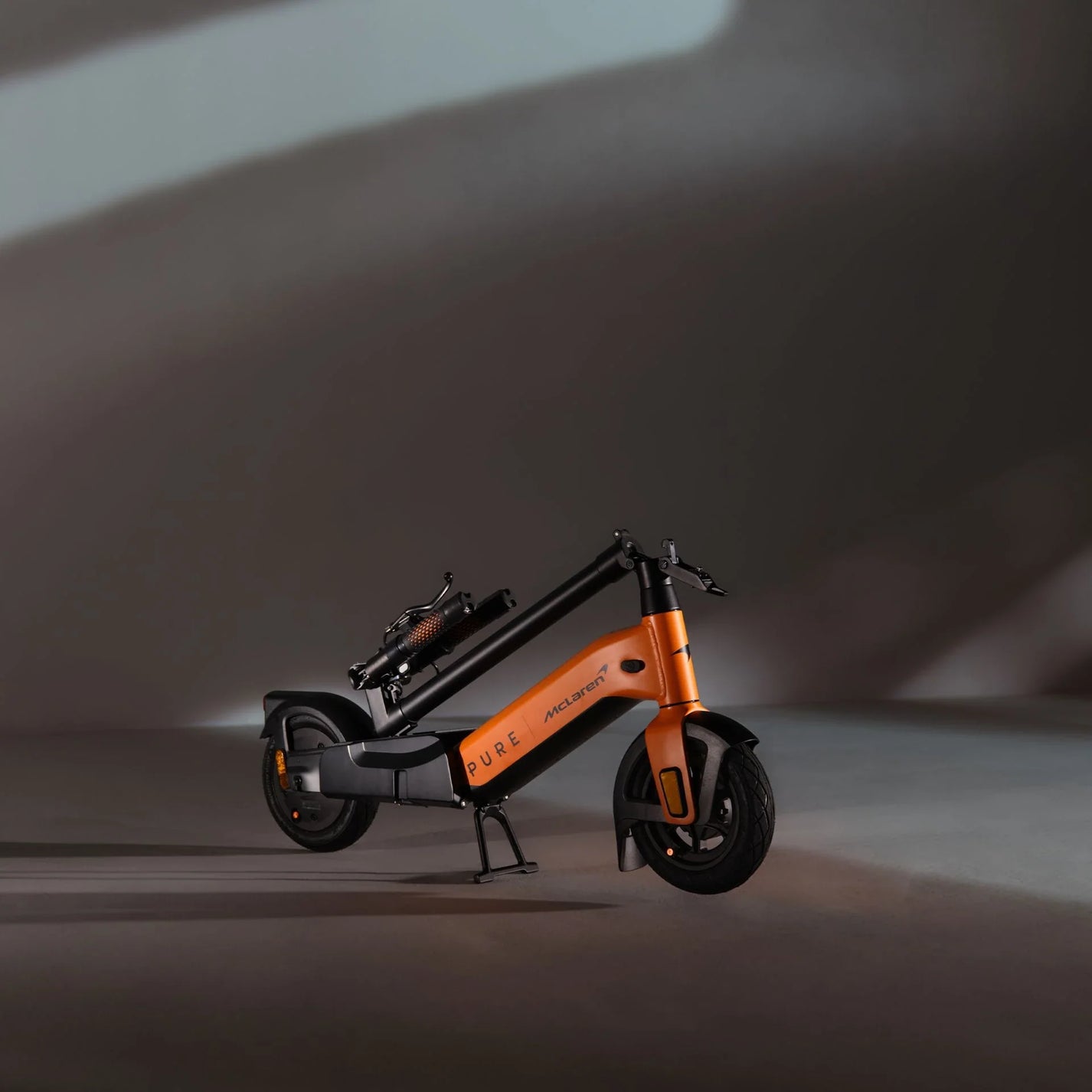 Electric scooter Pure Advance+ McLaren Edition – orange variant, folded view