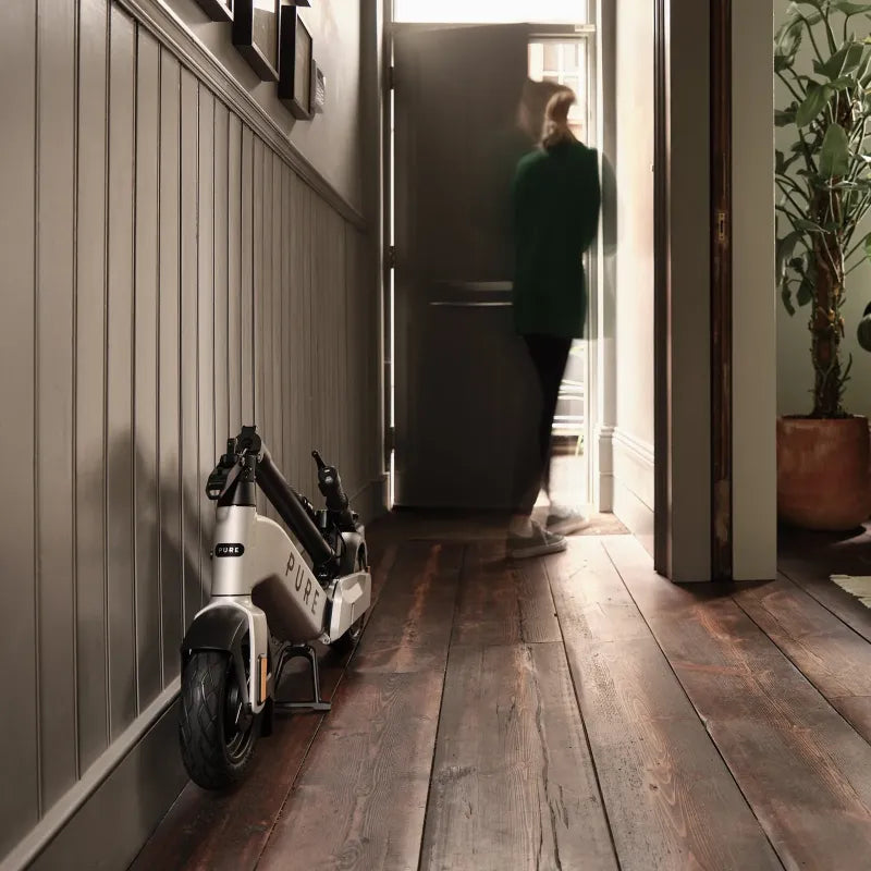 Electric scooter Pure Advance+ McLaren Edition – folded, standing in hallway