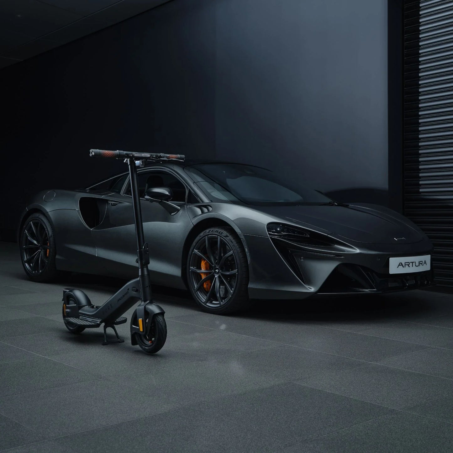 Electric scooter Pure Advance+ McLaren Edition – black variant next to sports car
