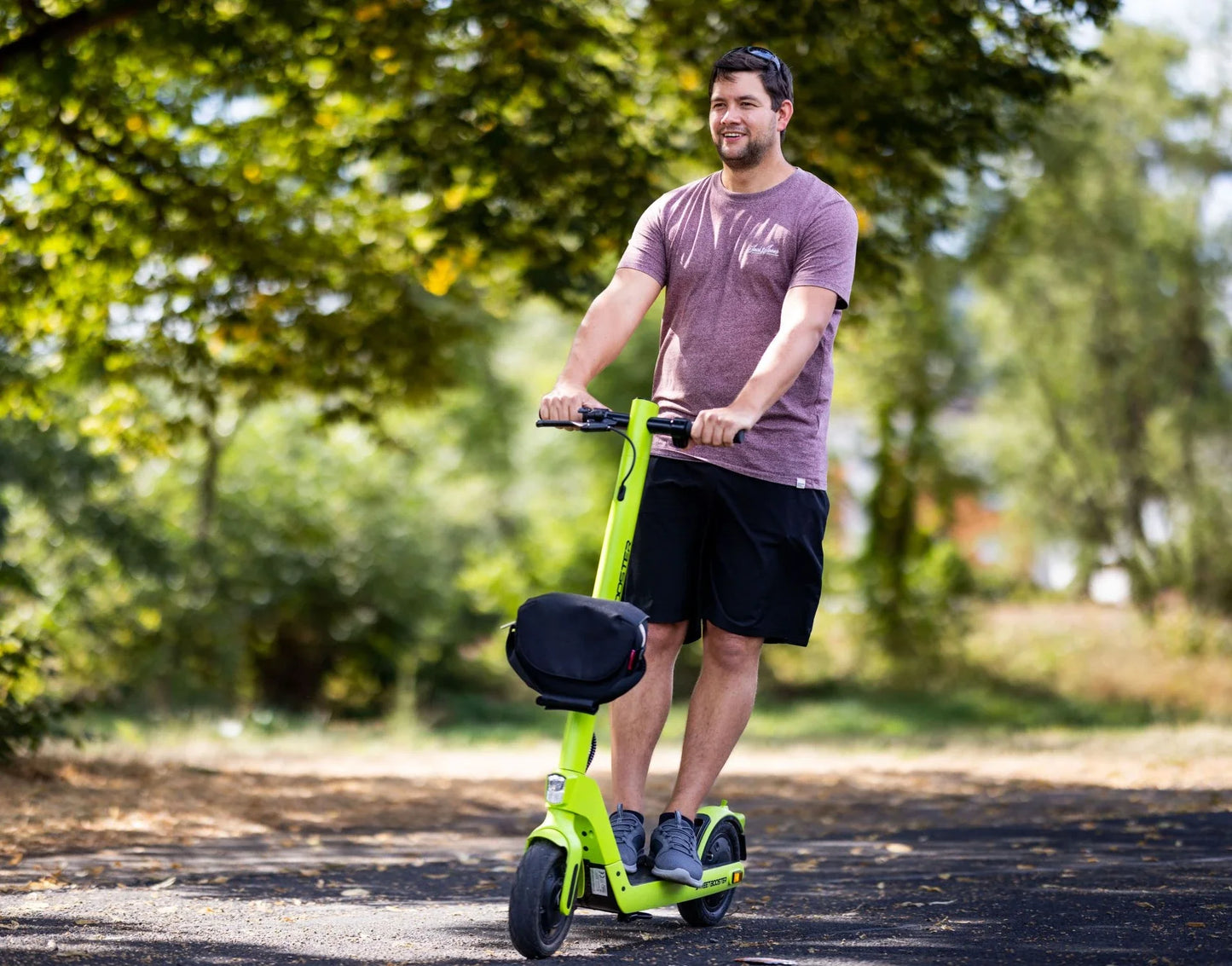 Electric scooter StreetBooster Sirius – man riding with optional seat attachment