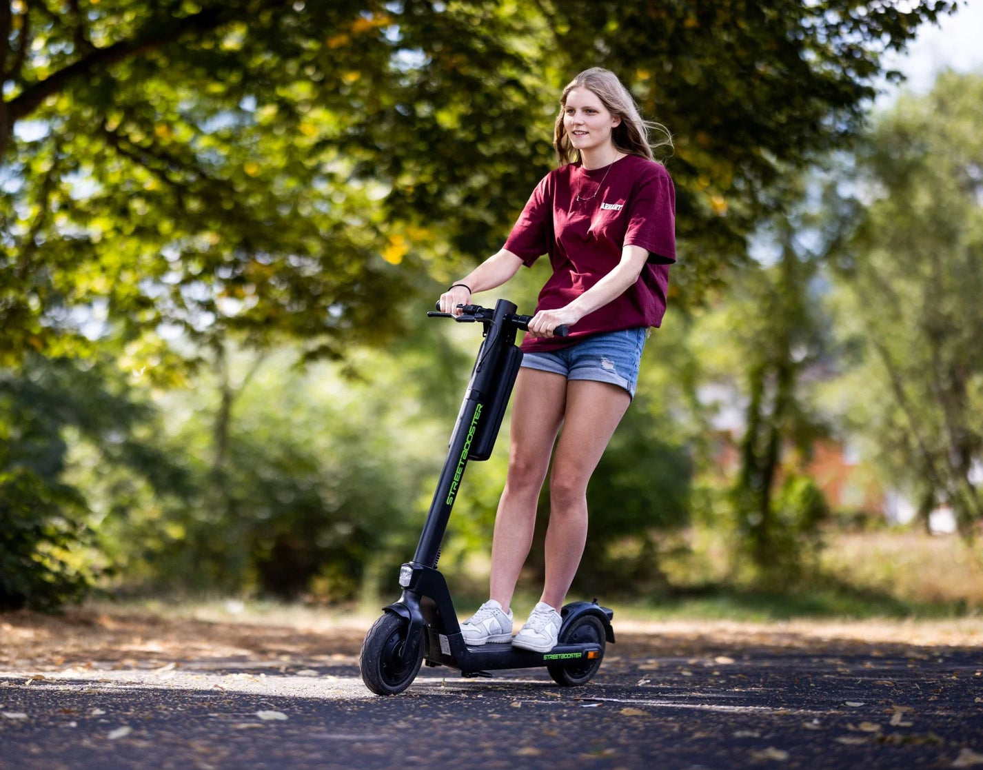 Electric scooter StreetBooster Sirius – woman riding on paved path