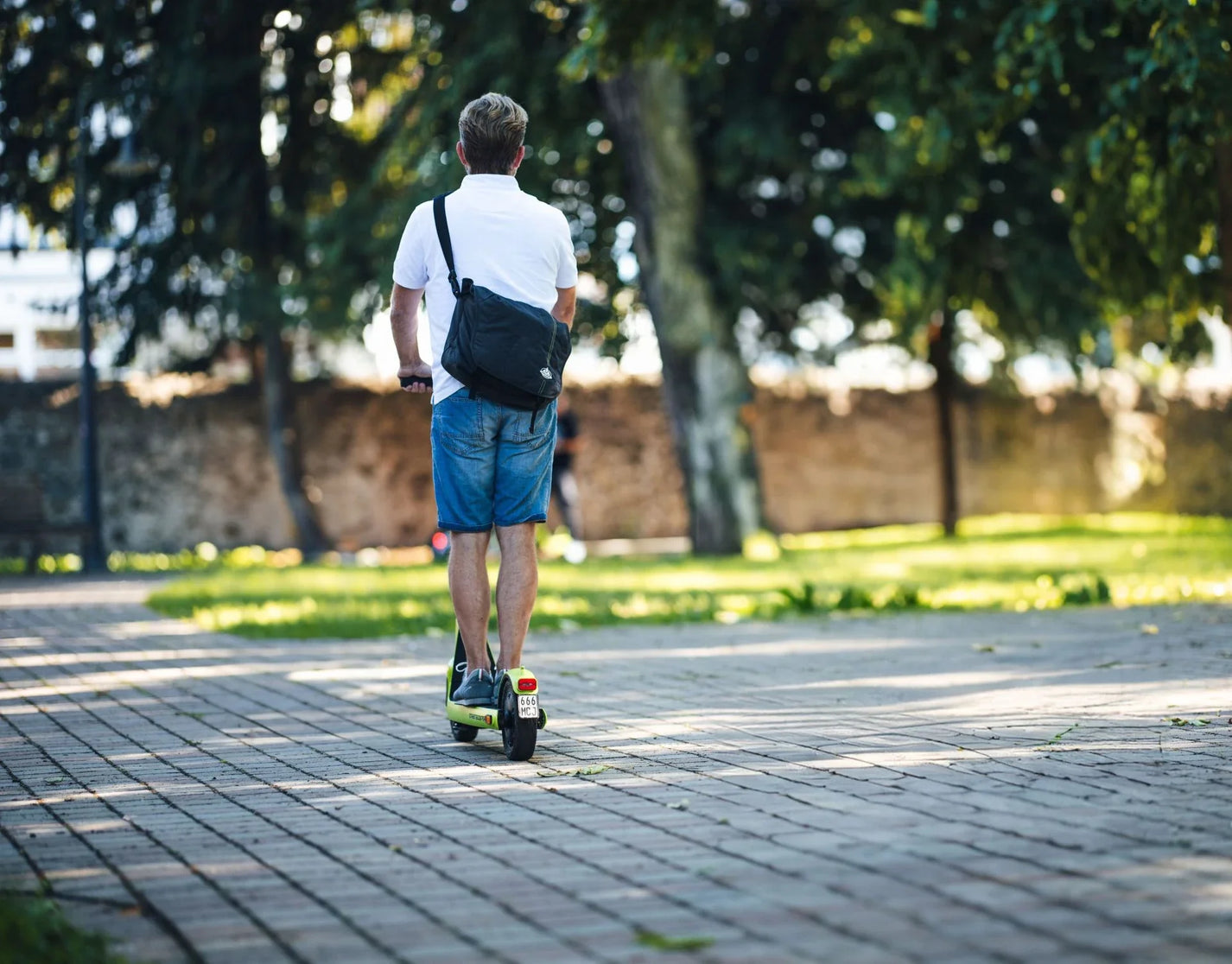 Electric scooter StreetBooster Sirius – man riding away on paved path