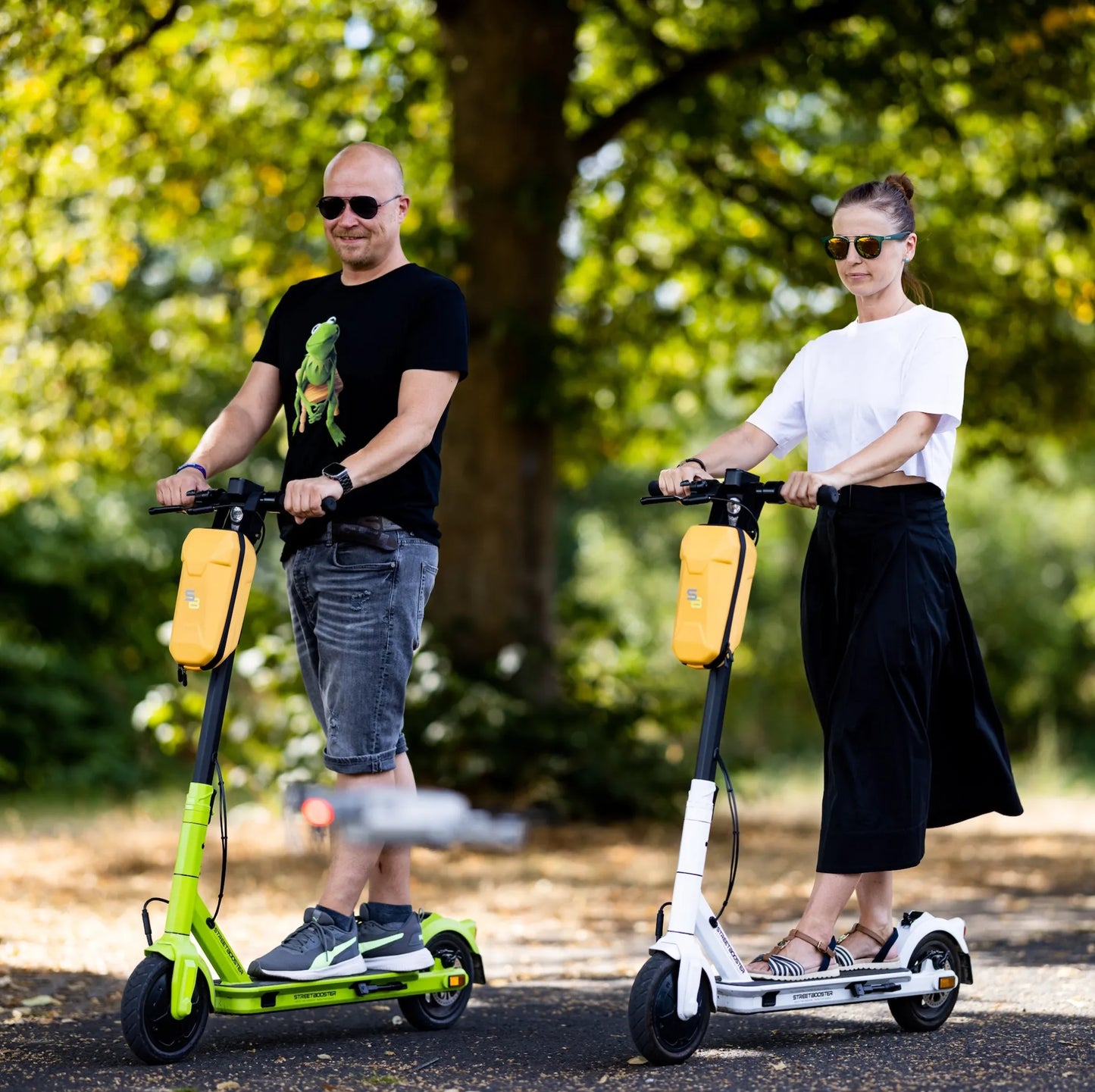 Električni romobil StreetBooster Vega – muškarac i žena voze romobile u parku
