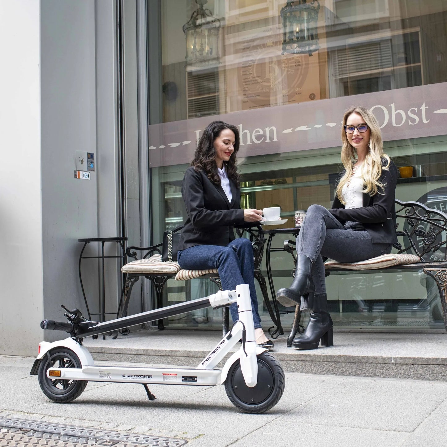 Električni romobil StreetBooster Vega – sklopljeni bijeli romobil s dvije žene