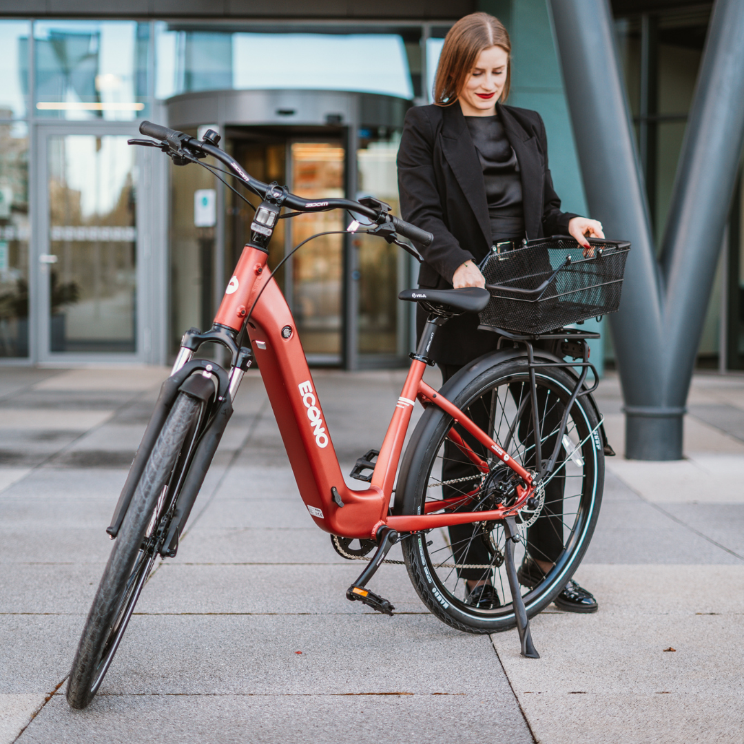 Electric bicycle ECONO Apes CITY EER4 – woman standing with bike, front three-quarter view