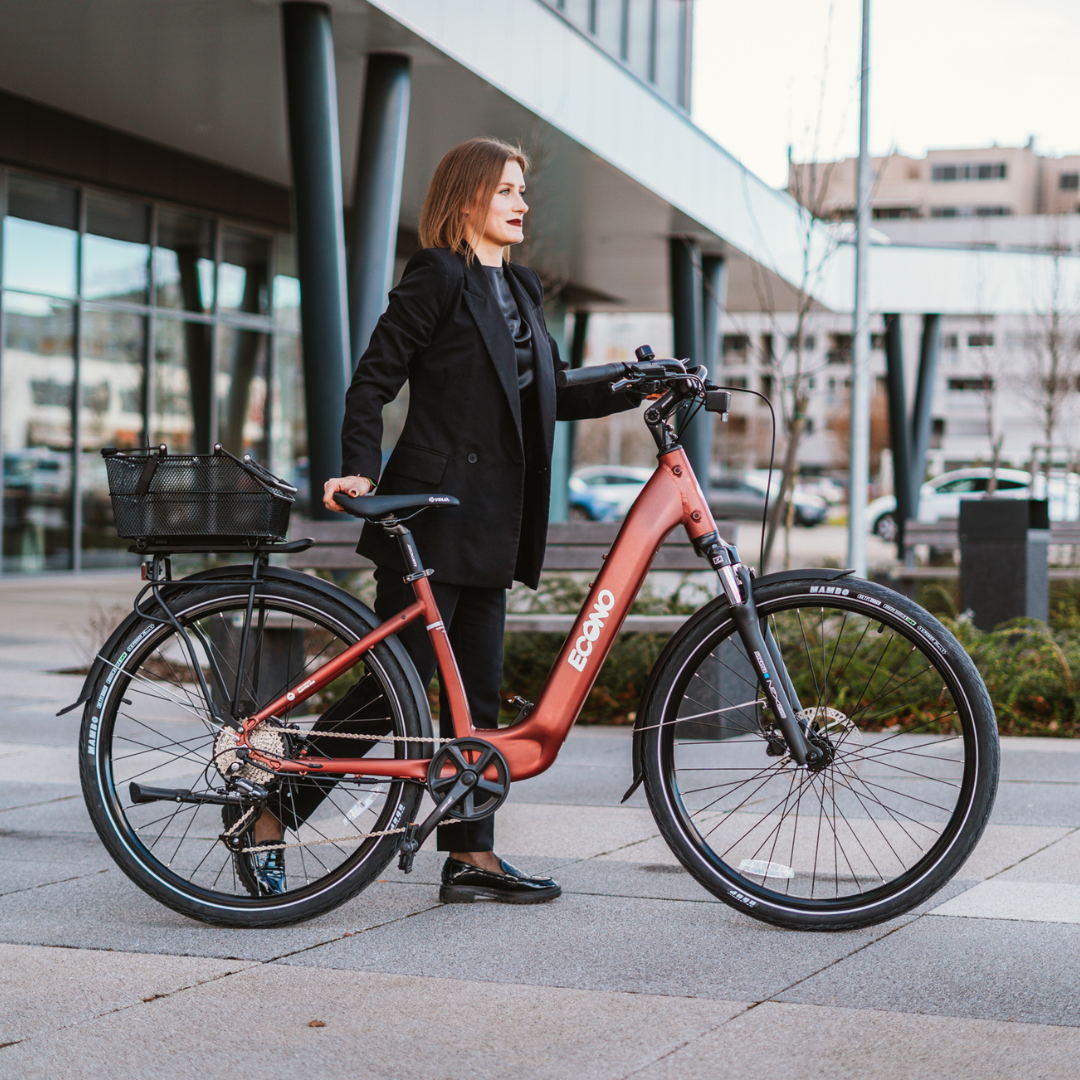 Electric bicycle ECONO Apes CITY EER4 – woman standing with bike, front three-quarter view