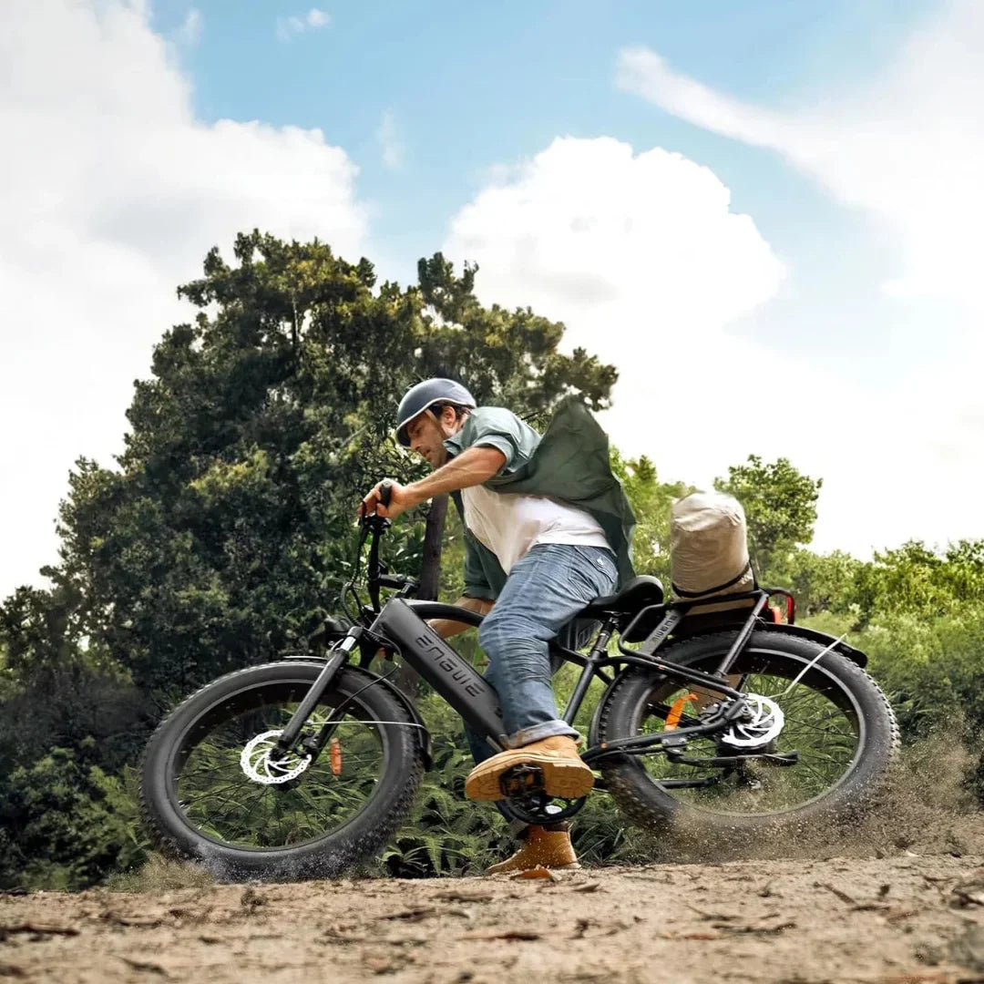 Electric Bike Engwe E26 features a rider performing a stunt on rugged terrain, showcasing durability and style.