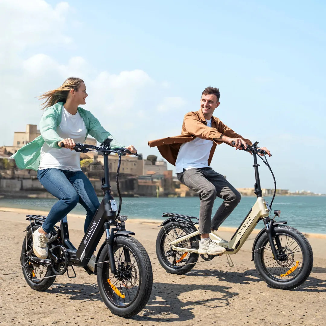 Electric Bike Engwe L20 3.0 Boost features two riders smiling while cycling along a scenic waterfront.