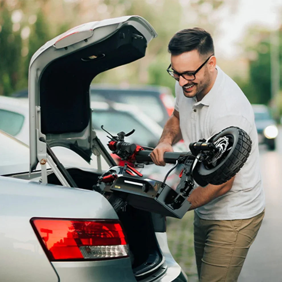 Electric Scooter Engwe Y600s, featuring a compact design, is being loaded into a car trunk by a smiling user.