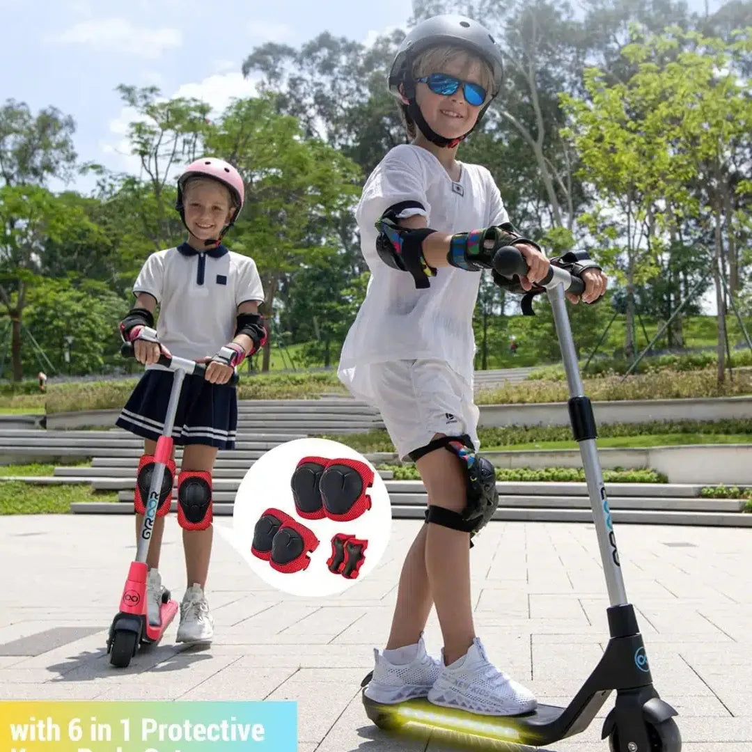 Two kids ride a Gyroor H30 electric scooter, wearing helmets and protective gear in a park