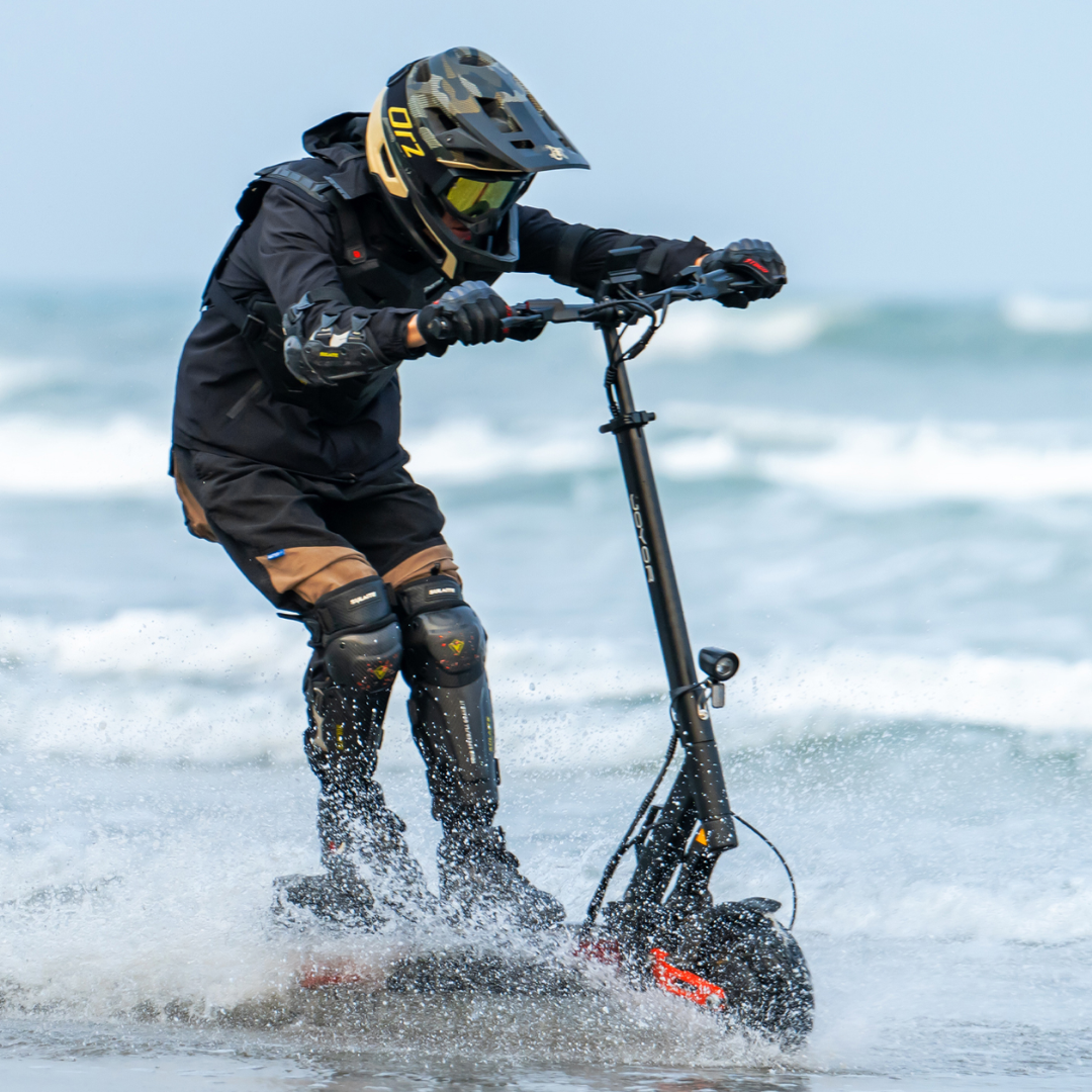 Electric scooter Joyor T10 – person riding through water on beach