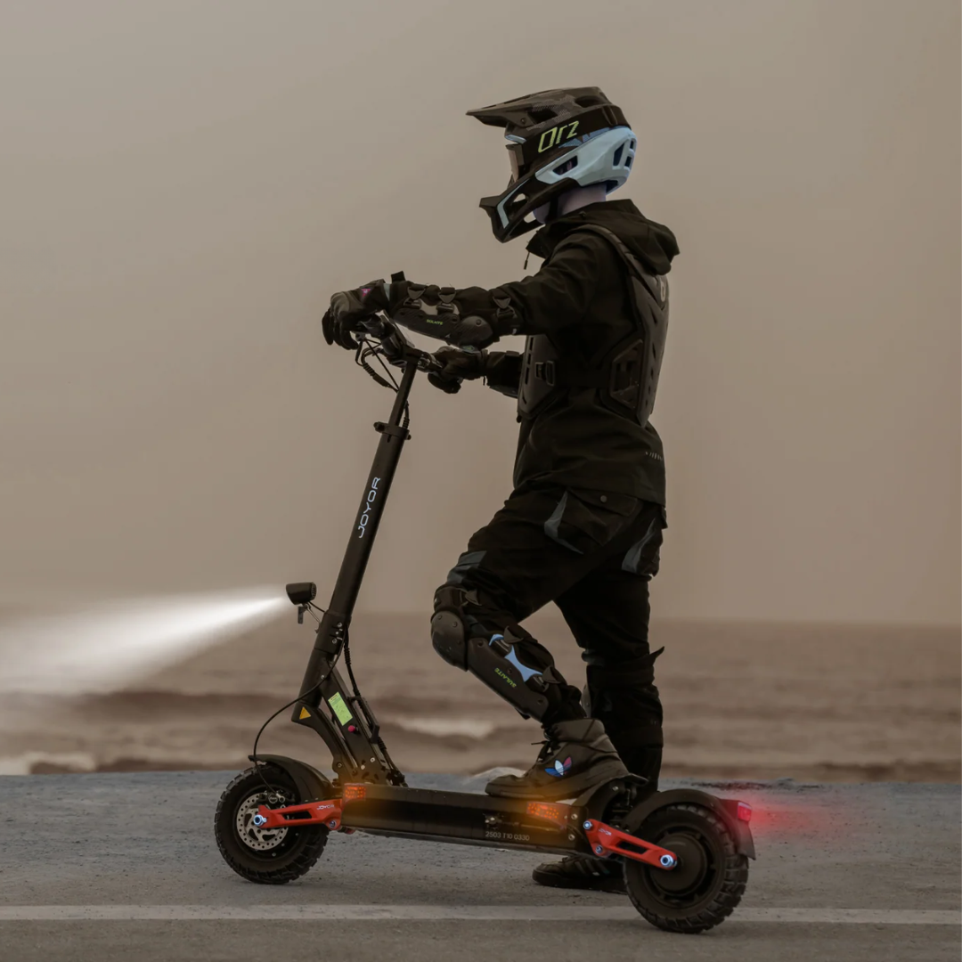 Electric scooter Joyor T10 – person riding at dusk with lights on