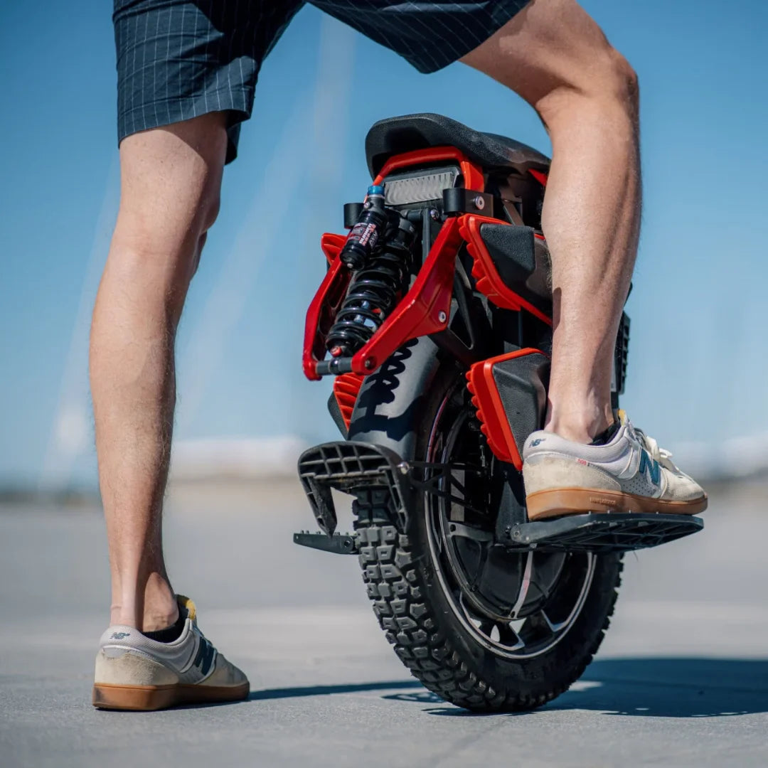 Electric Unicycle Kingsong S22 Pro Plus, showing a rider's leg next to the sleek red and black design.