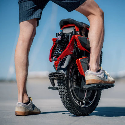 Electric Unicycle Kingsong S22 Pro Plus, showing a rider's leg next to the sleek red and black design.