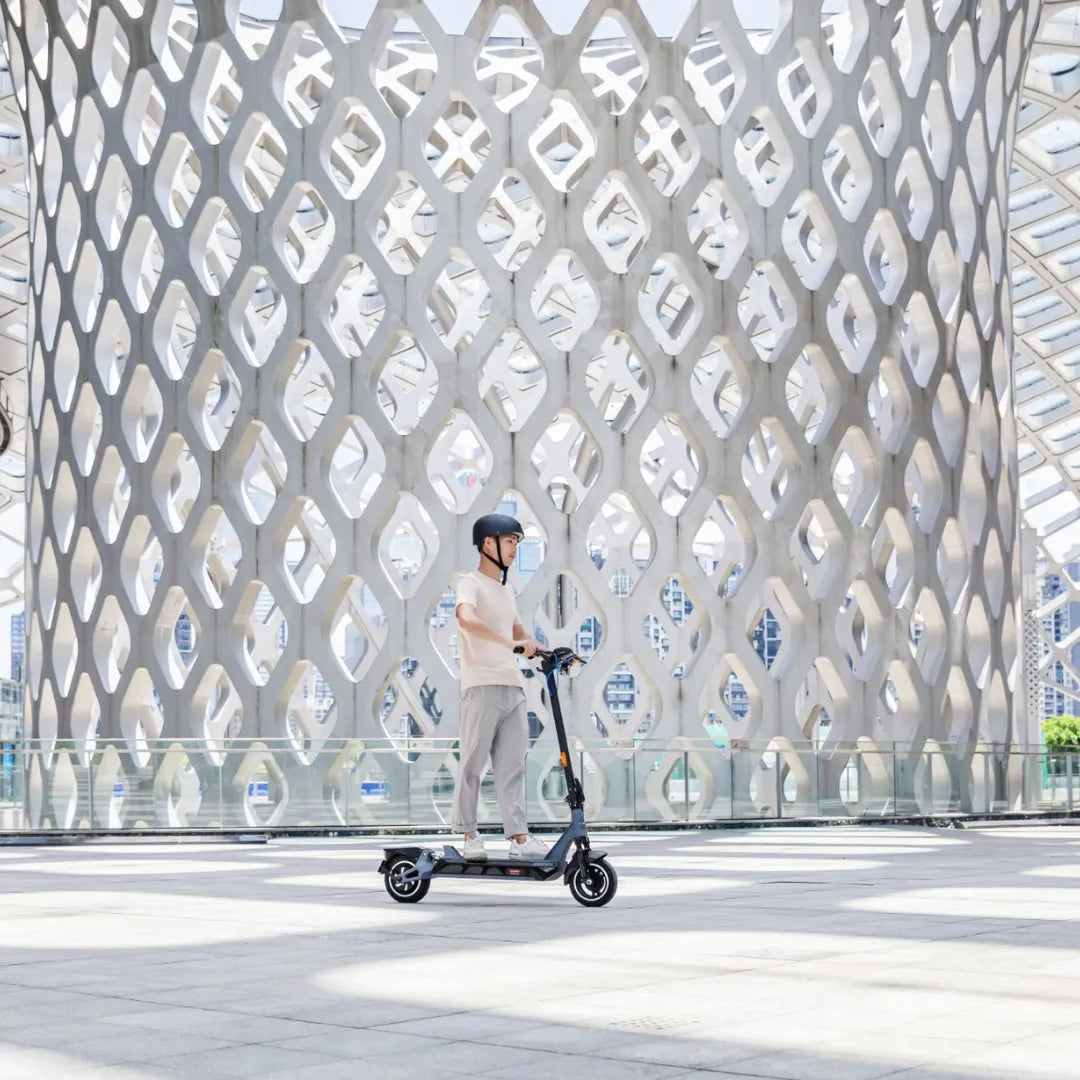 Electric Scooter Kingsong N12 Pro features a sleek design, showcased in a modern urban setting, with a rider.